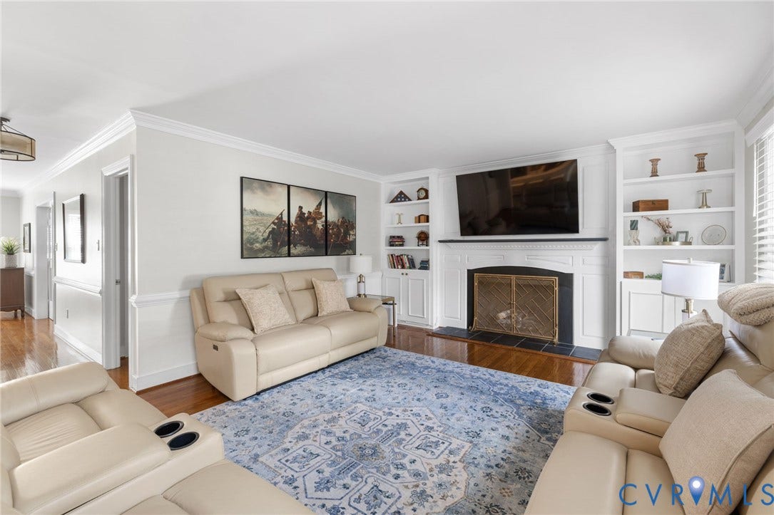White fireplace with a dark-toned mantel, flanked by built-in shelving and lower cabinetry