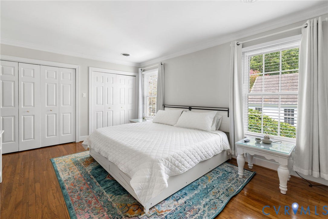 Hardwood flooring, white bi-fold closet doors, crown molding, double-hung window, and recessed lighting