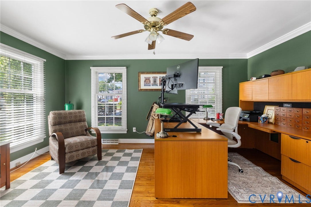 Hardwood flooring, painted walls, crown molding, double windows with blinds, and a ceiling fan