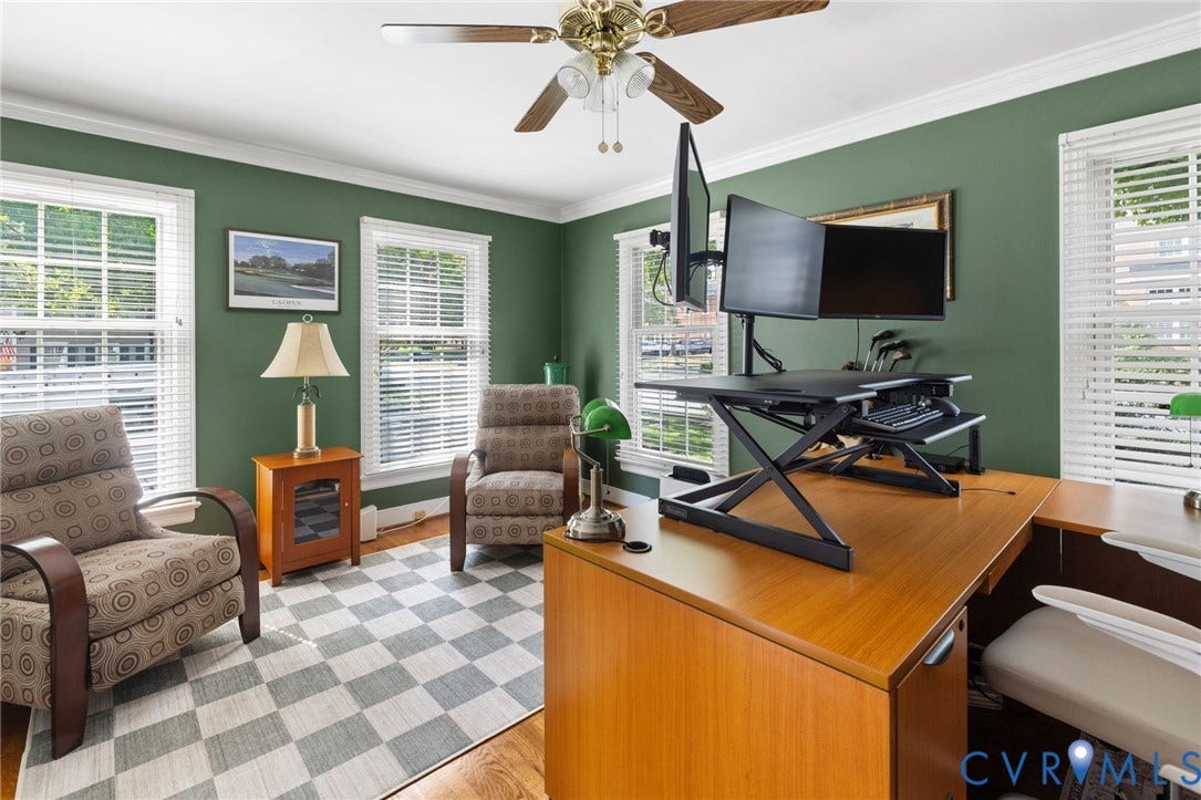 Wood-finish flooring, multiple windows with blinds, crown molding, and a ceiling fan with light fixture