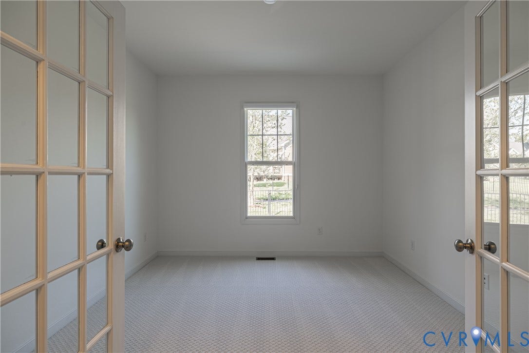 Room featuring French doors with glass panes, a single window, and new carpeting