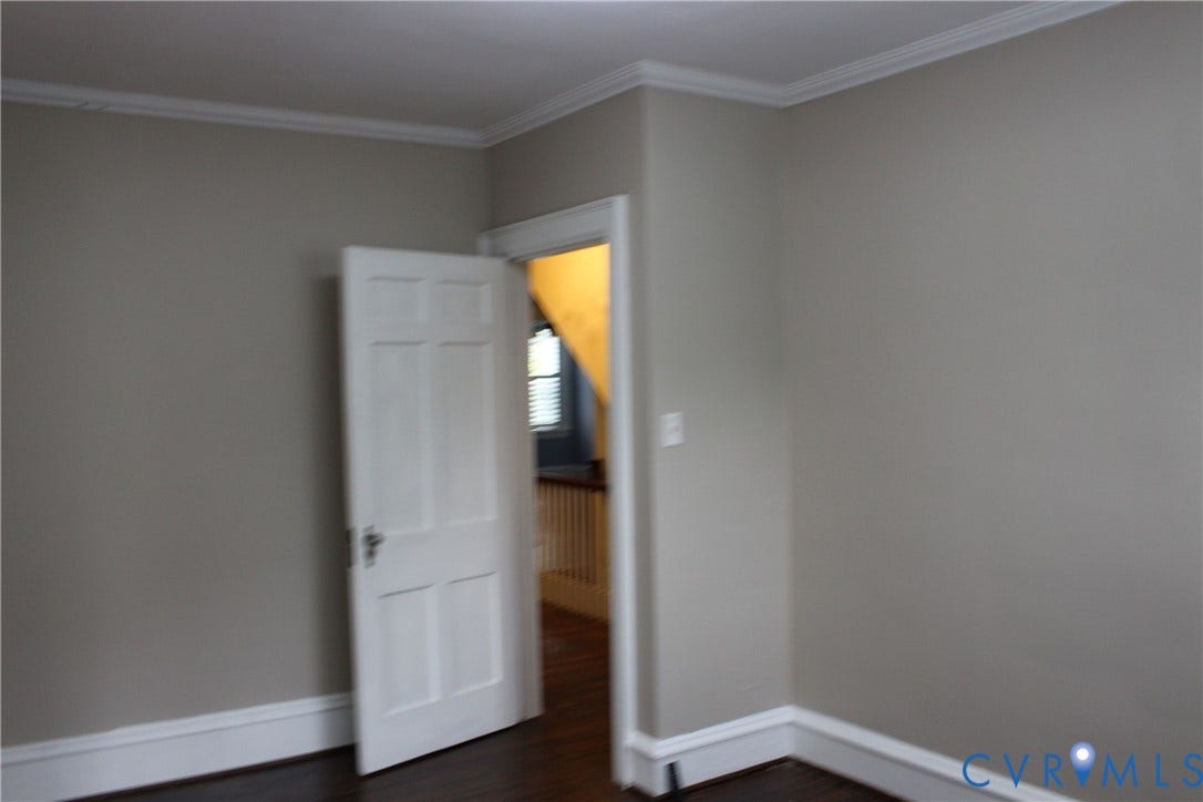 3013 Hawthorne, Richmond, VA 23222 Neutral wall tones with crown molding, panel door, and dark wood-finish flooring