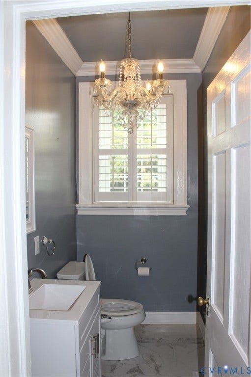 3013 Hawthorne, Richmond, VA 23222 Elegant powder room featuring a crystal chandelier, white shaker-style cabinetry with a vessel sink, marble-finish flooring, and wainscoting with coordinating upper wall treatment