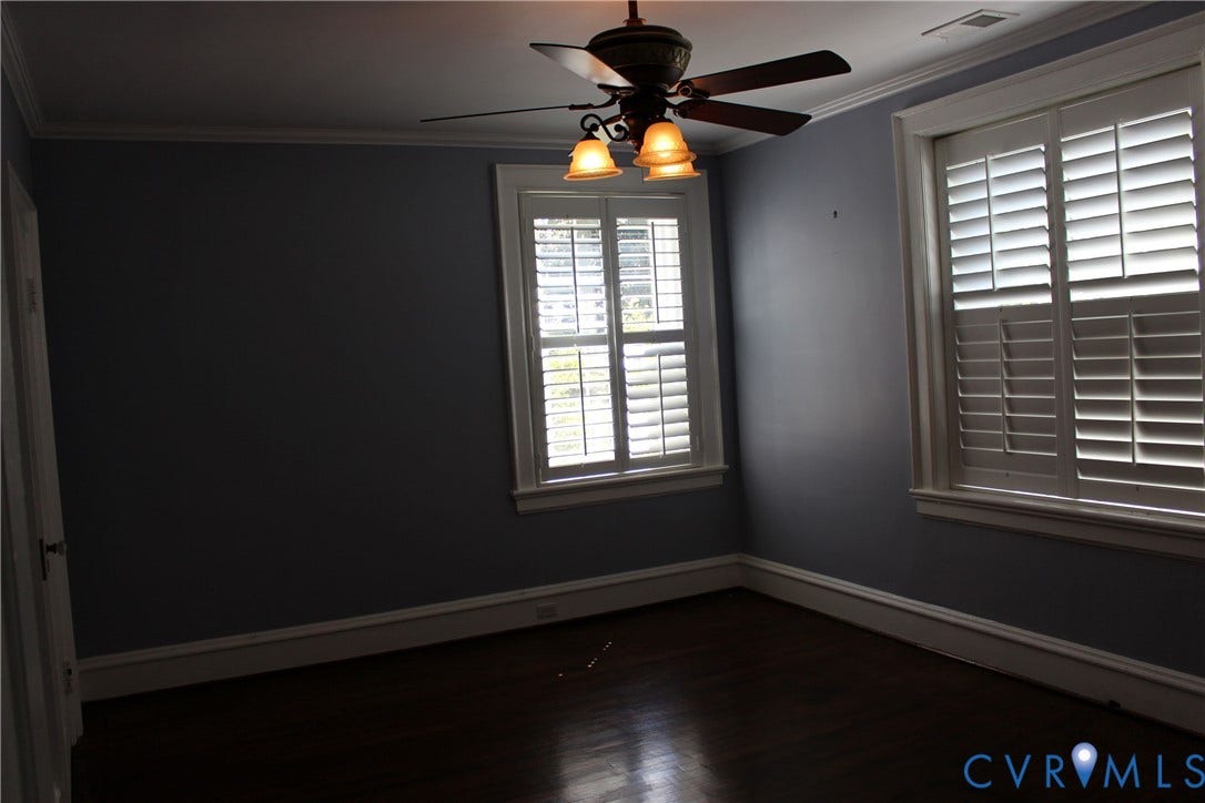3013 Hawthorne, Richmond, VA 23222 Spacious bedroom with neutral wall finishes, dark wood-finish flooring, and abundant natural light from dual shuttered windows
