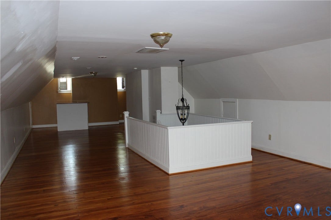 3013 Hawthorne, Richmond, VA 23222 Expansive upper-level space featuring rich wood-finish flooring, white paneling accents, and a distinctive hanging light fixture