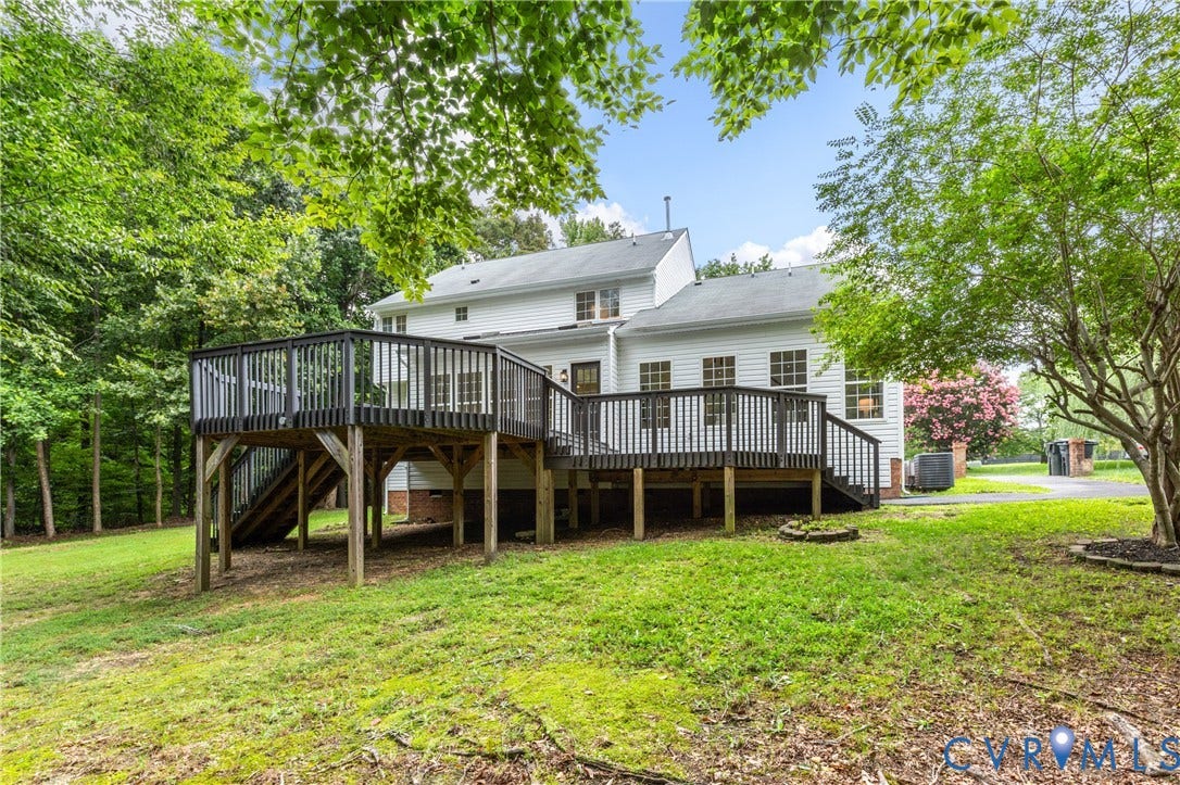 3929 Meadowview Lane, Richmond, VA 23223 Expansive rear deck with dark wood railing and steps, white siding exterior, and multiple windows