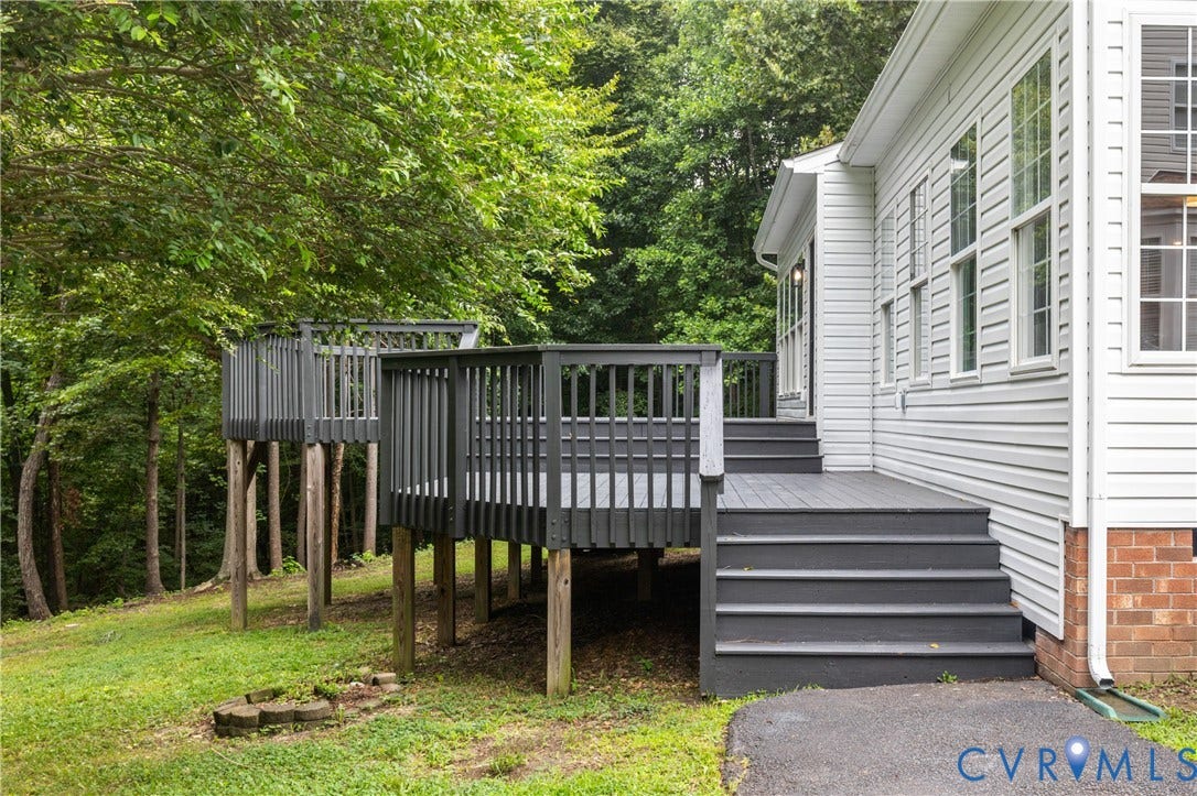 3929 Meadowview Lane, Richmond, VA 23223 Multi-level wood deck with dark grey finish and steps, white siding exterior, and multiple windows
