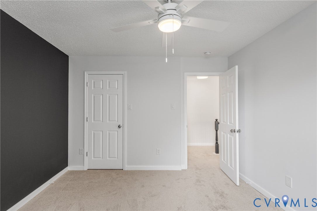 3929 Meadowview Lane, Richmond, VA 23223 Carpeted flooring, ceiling fan with integrated lighting, a six-panel interior door, and a contrasting accent wall