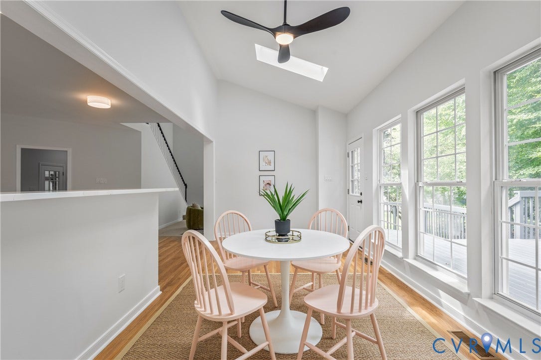 3929 Meadowview Lane, Richmond, VA 23223 Vaulted ceiling with skylight, black ceiling fan, wood-finish flooring, numerous windows, and a glass-paneled exterior door