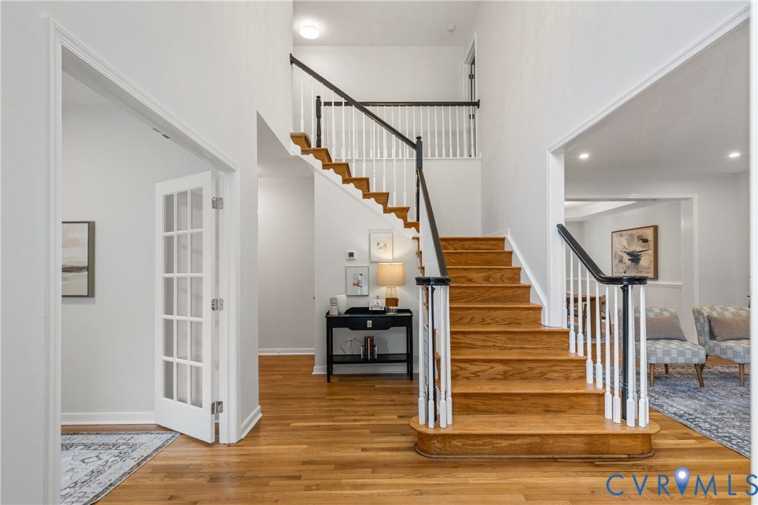 3929 Meadowview Lane, Richmond, VA 23223 Two-story foyer featuring wood-finish flooring, a grand staircase with white risers and dark wood handrails, and a French door entry