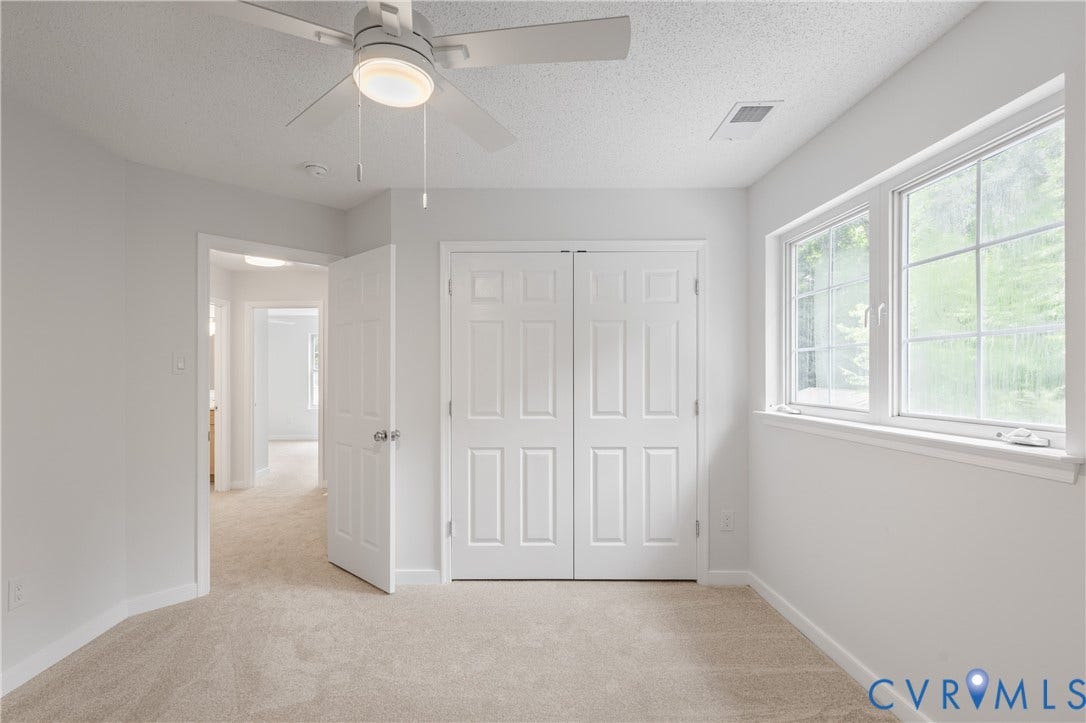 3929 Meadowview Lane, Richmond, VA 23223 Neutral-toned carpeting, white walls, and a ceiling fan with integrated lighting