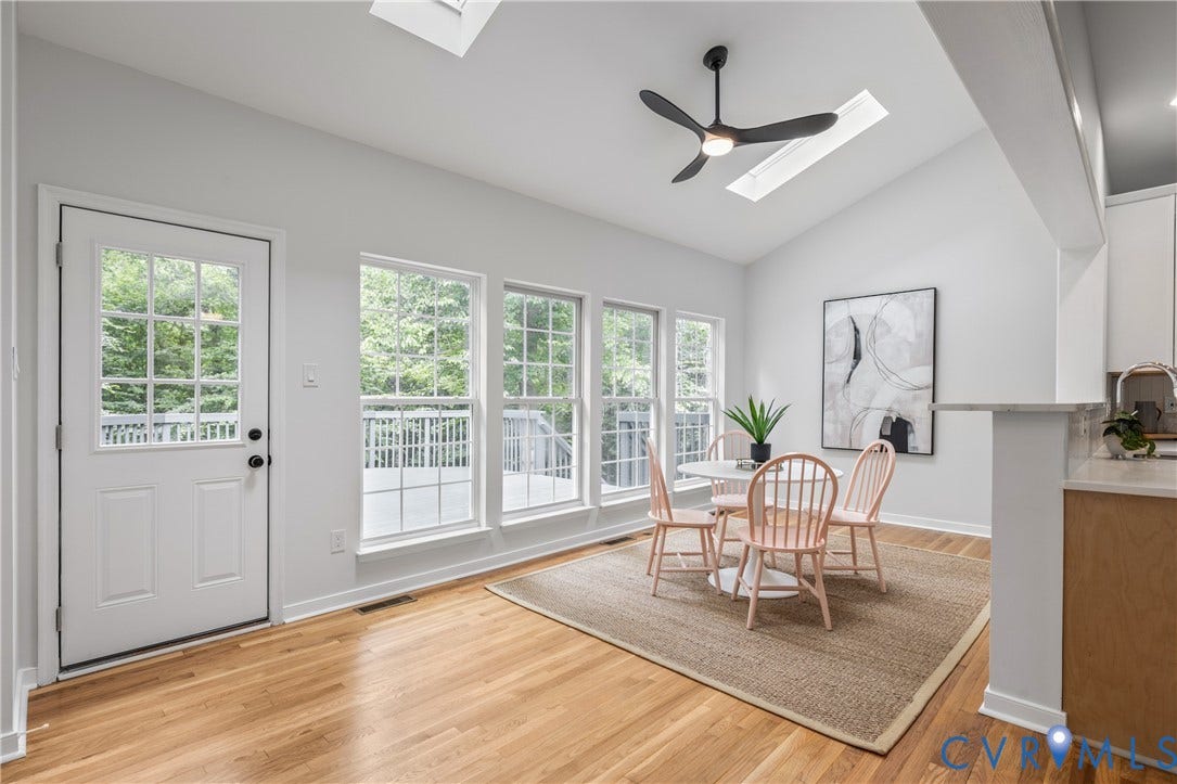 3929 Meadowview Lane, Richmond, VA 23223 Vaulted ceiling with skylight, wood-finish flooring, white paneled door with glass inserts, multiple windows, and a ceiling fan