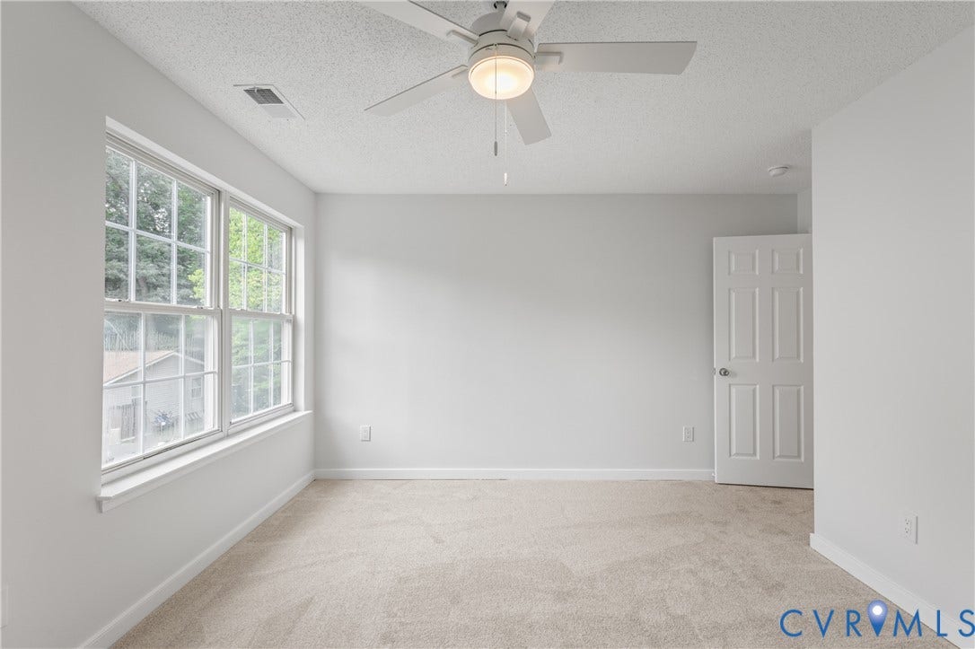 3929 Meadowview Lane, Richmond, VA 23223 Neutral wall paint, ceiling fan with integrated lighting, paneled door, and carpeted flooring