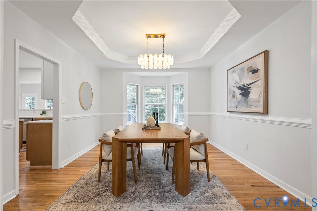 3929 Meadowview Lane, Richmond, VA 23223 Tray ceiling with crown molding, bay windows, wood-finish flooring, chair rail molding, and a contemporary chandelier