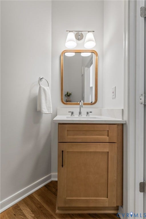 3929 Meadowview Lane, Richmond, VA 23223 Elegant bathroom vanity featuring warm wood-finish cabinetry with a white countertop, chrome faucet, and integrated sink
