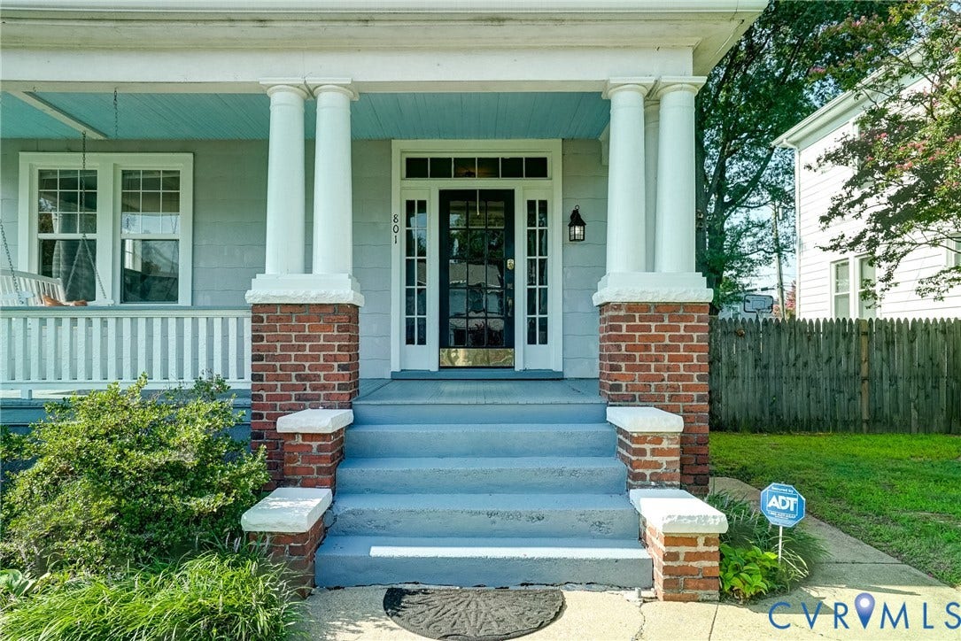 801 Edge Hill Road, Battery Court, Richmond, VA 23222 Inviting porch with brick columns, white railings, and a solid wood entry door with glass paneling