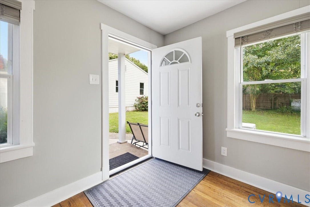 7232 Hopkins Road, North Chesterfield, VA 23237 White paneled front door with an arched transom, wood-finish flooring, and light gray walls