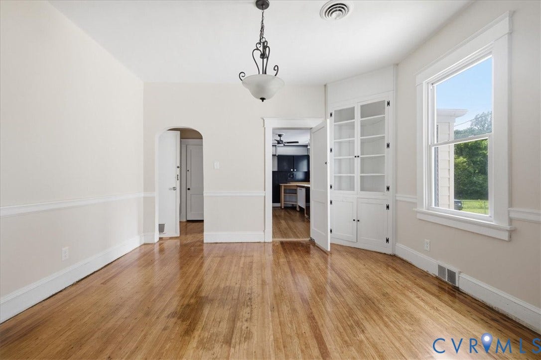 7232 Hopkins Road, North Chesterfield, VA 23237 Hardwood flooring, crown molding, built-in cabinetry, arched doorway, and a ceiling-mounted light fixture