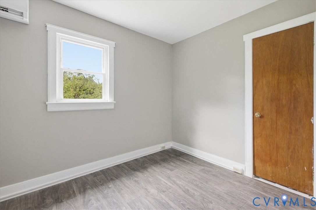 7232 Hopkins Road, North Chesterfield, VA 23237 Gray-toned walls with wood-finish flooring, white window trim, and a split air conditioning unit