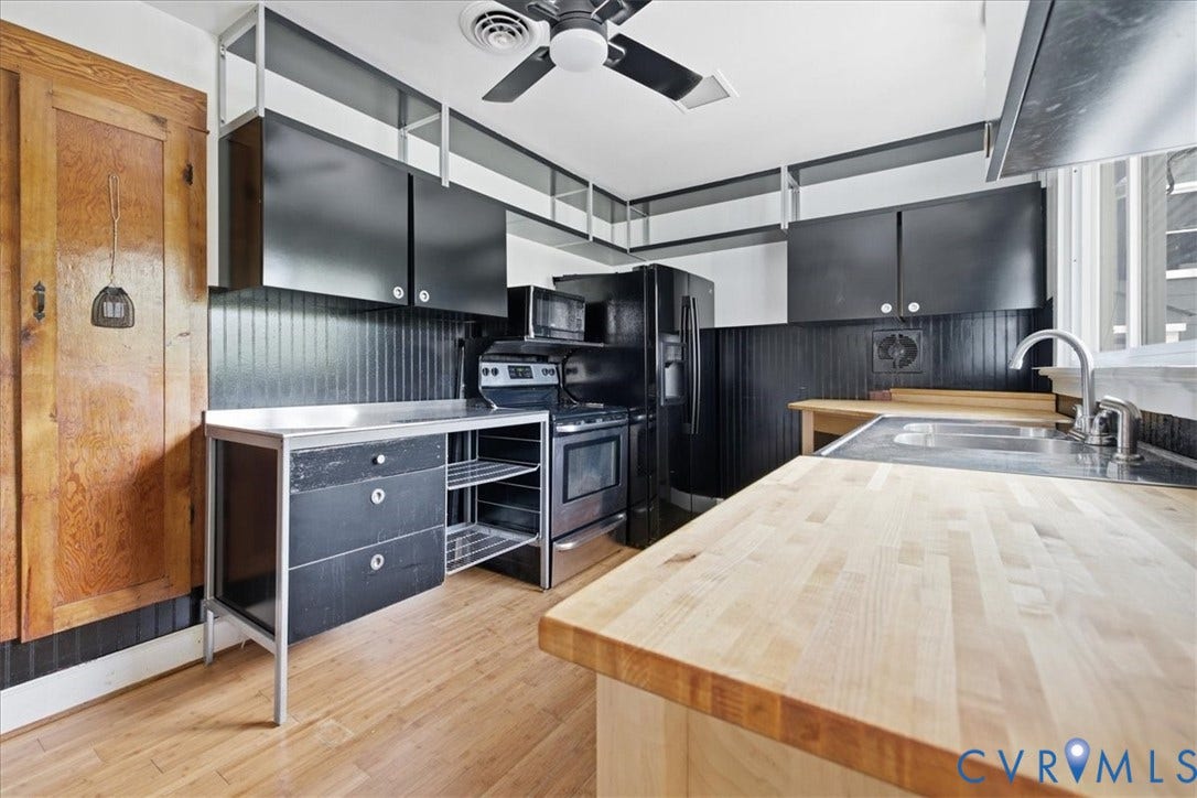 7232 Hopkins Road, North Chesterfield, VA 23237 Wood-finish flooring with solid wood countertops, black cabinetry, and stainless steel sink