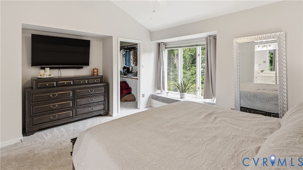 Carpeted interior featuring a built-in window seat, recessed wall niche, and an open closet entry