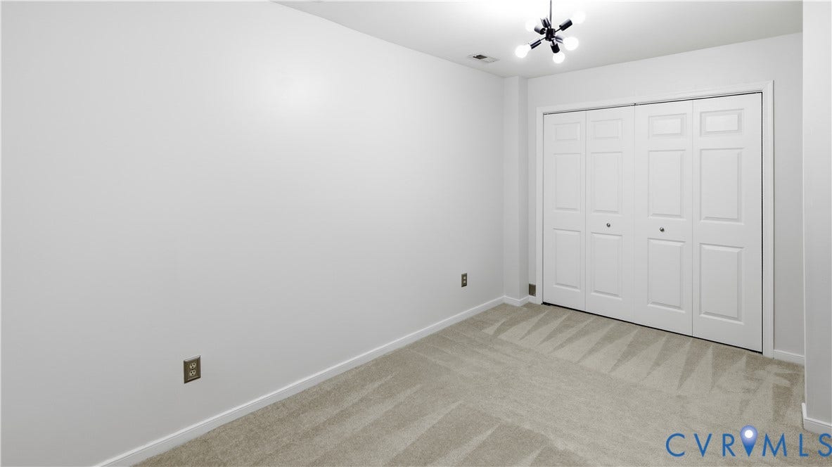 Recessed lighting, modern ceiling fixture, neutral wall color, carpeted flooring, and bi-fold doors