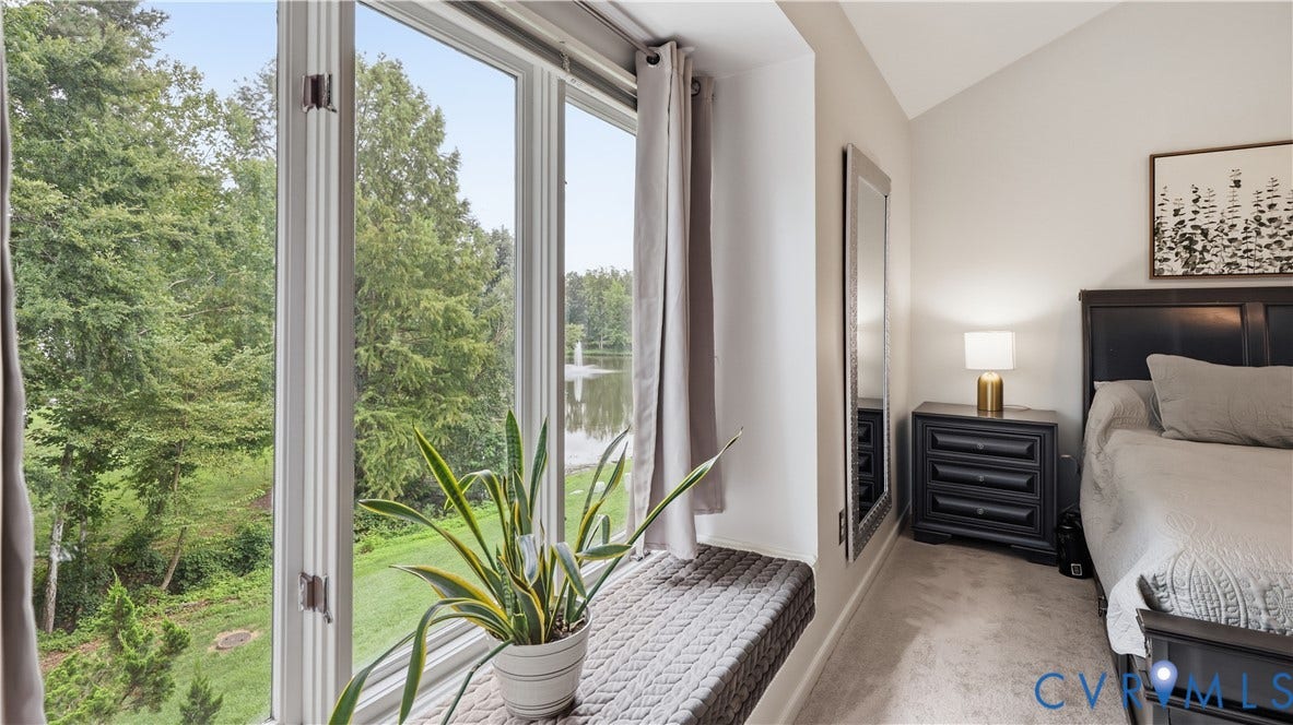 Window seating with soft gray upholstery, complemented by a tall vaulted ceiling and neutral wall tones