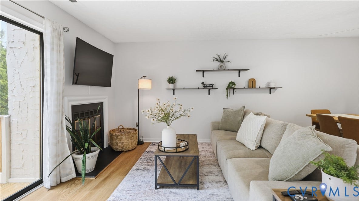 Recessed fireplace with white mantel, light wood-finish flooring, and a sliding glass door leading to an outdoor space