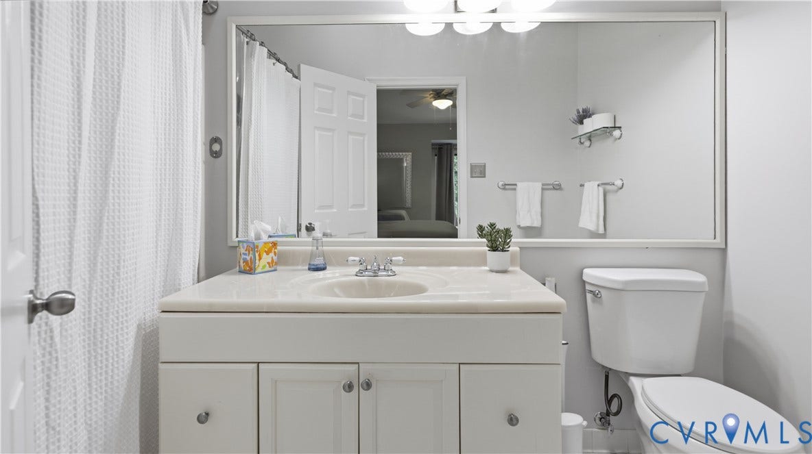 White vanity with integrated sink, chrome faucet, and under-cabinet storage