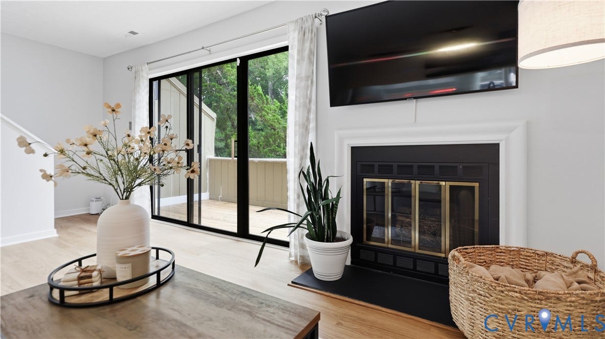 Living area featuring a fireplace with a white mantel, black firebox, and brass-tone doors