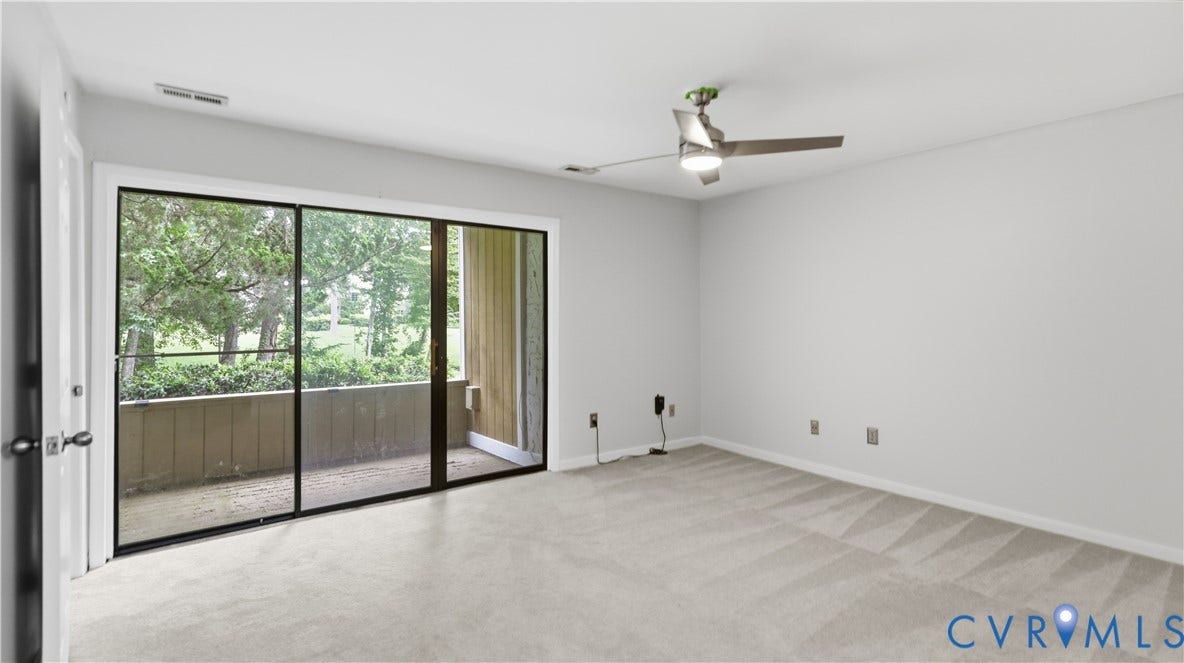 Sliding glass door leading to a private patio, ceiling fan with integrated lighting, and neutral carpet flooring
