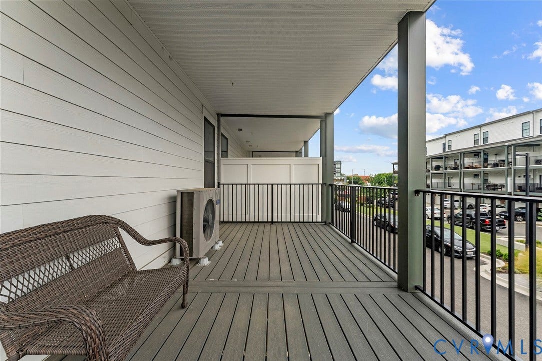 2445 Ownby Lane, #B15, Greater Scott's Addition, Richmond, VA 23220 Covered outdoor balcony featuring composite decking, white horizontal siding, and black metal railings