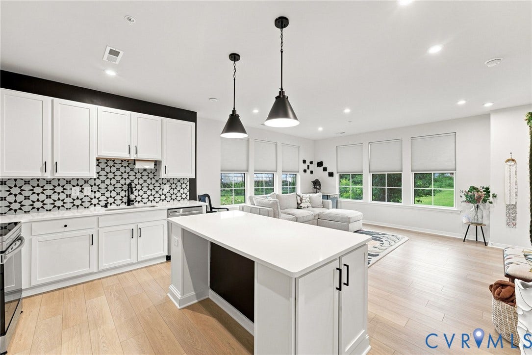 2445 Ownby Lane, #B15, Greater Scott's Addition, Richmond, VA 23220 Kitchen featuring white cabinetry, patterned backsplash, black pendant lighting, and a kitchen island with a white countertop