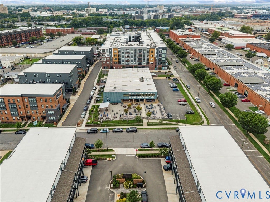 2445 Ownby Lane, #B15, Greater Scott's Addition, Richmond, VA 23220 Urban mixed-use development with multi-story residential buildings, commercial structures, and dedicated parking areas