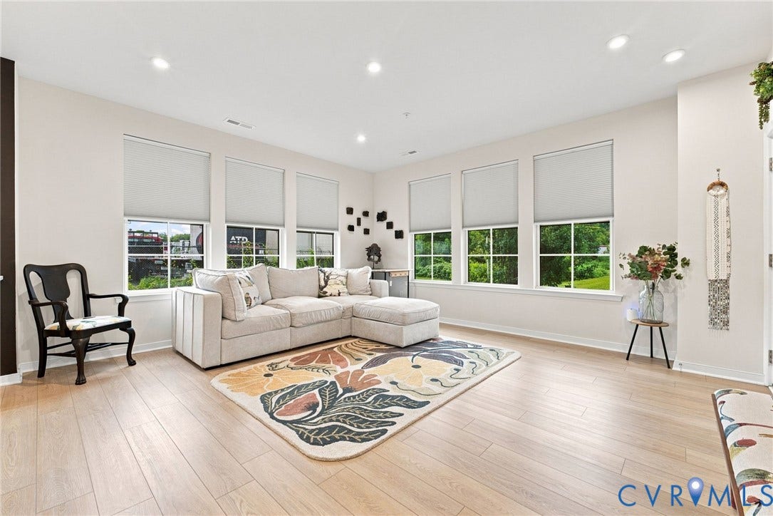 2445 Ownby Lane, #B15, Greater Scott's Addition, Richmond, VA 23220 Recessed lighting illuminates the expansive room featuring light wood-finish flooring and multiple windows with roller shades