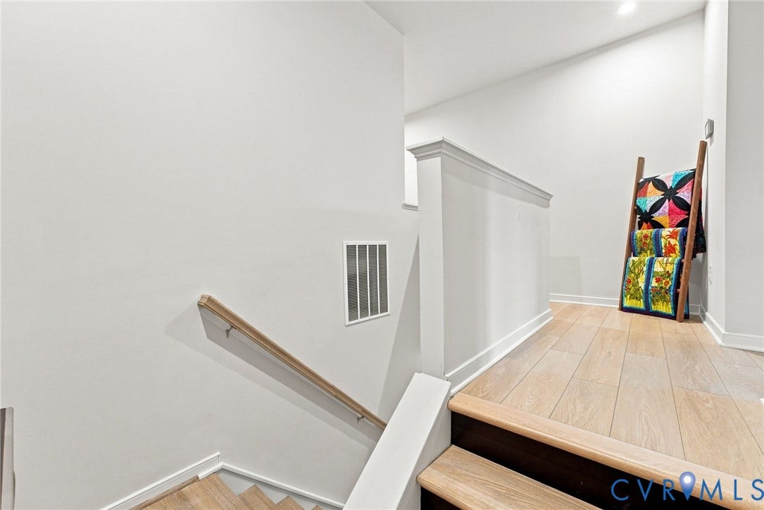 2445 Ownby Lane, #B15, Greater Scott's Addition, Richmond, VA 23220 Wood-finish flooring, white painted walls, natural wood handrail, and staircase with dark risers