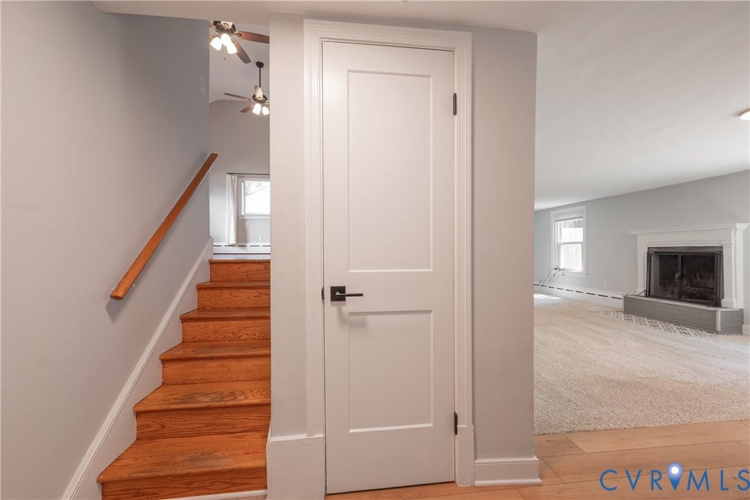5709 Monument Avenue, Richmond, VA 23226 Stairs from the Main level to the Lower level Rec Room with a storage closet and fireplace with mantel