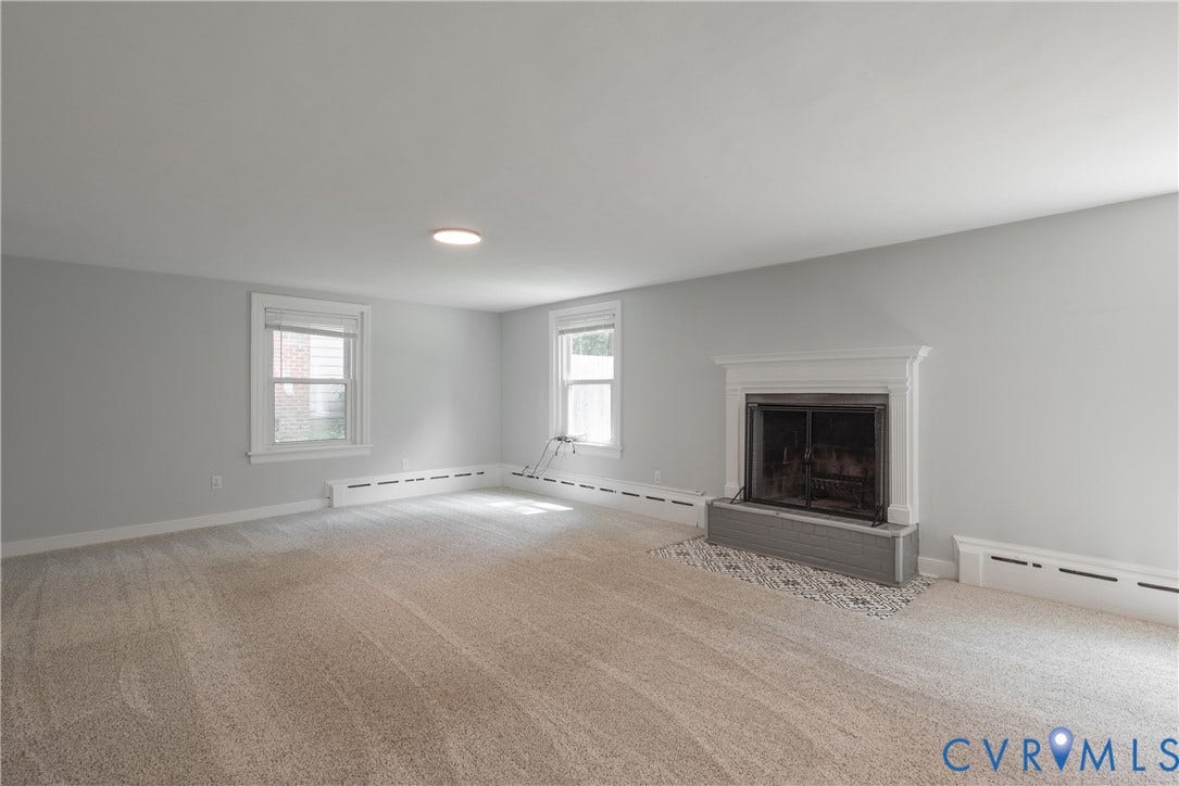 5709 Monument Avenue, Richmond, VA 23226 Rec Room with carpeted flooring, two windows with white trim, recessed lighting, and a fireplace with a white mantel and tiled custom hearth