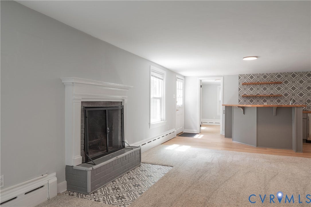 5709 Monument Avenue, Richmond, VA 23226 Fireplace with a white wood mantel, patterned tile hearth, and dark metal fire screen