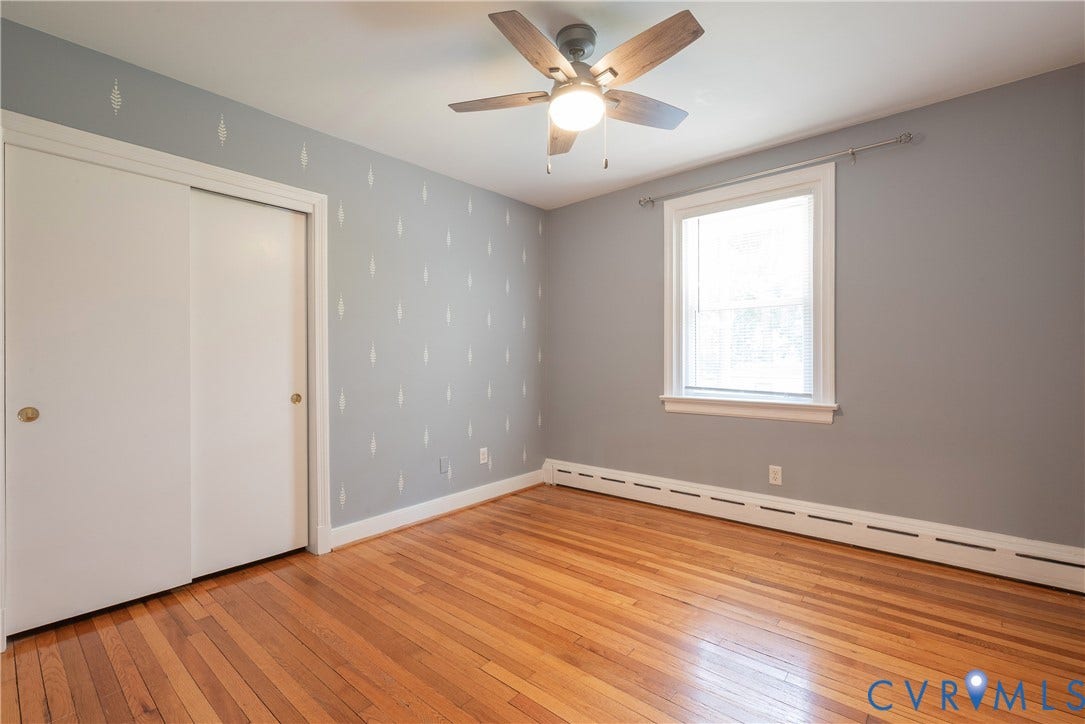 5709 Monument Avenue, Richmond, VA 23226 Bedroom #3 with Wood-finish flooring, white trim, large sliding closet doors, ceiling fan with integrated lighting, and a single window