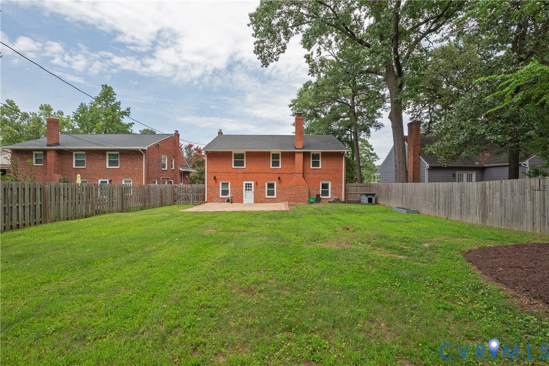 5709 Monument Avenue, Richmond, VA 23226 Yard, Expansive backyard with a manicured lawn, full privacy fencing, and a concrete patio