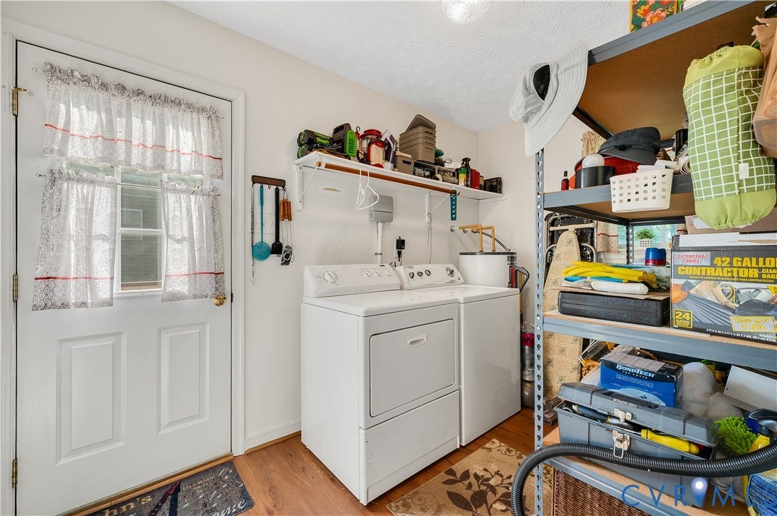 3117 Pinefields Drive, Henrico, VA 23231 Utility room featuring side-by-side washer and dryer with white enamel finish, wood-finish flooring, and extensive built-in shelving with organized storage throughout