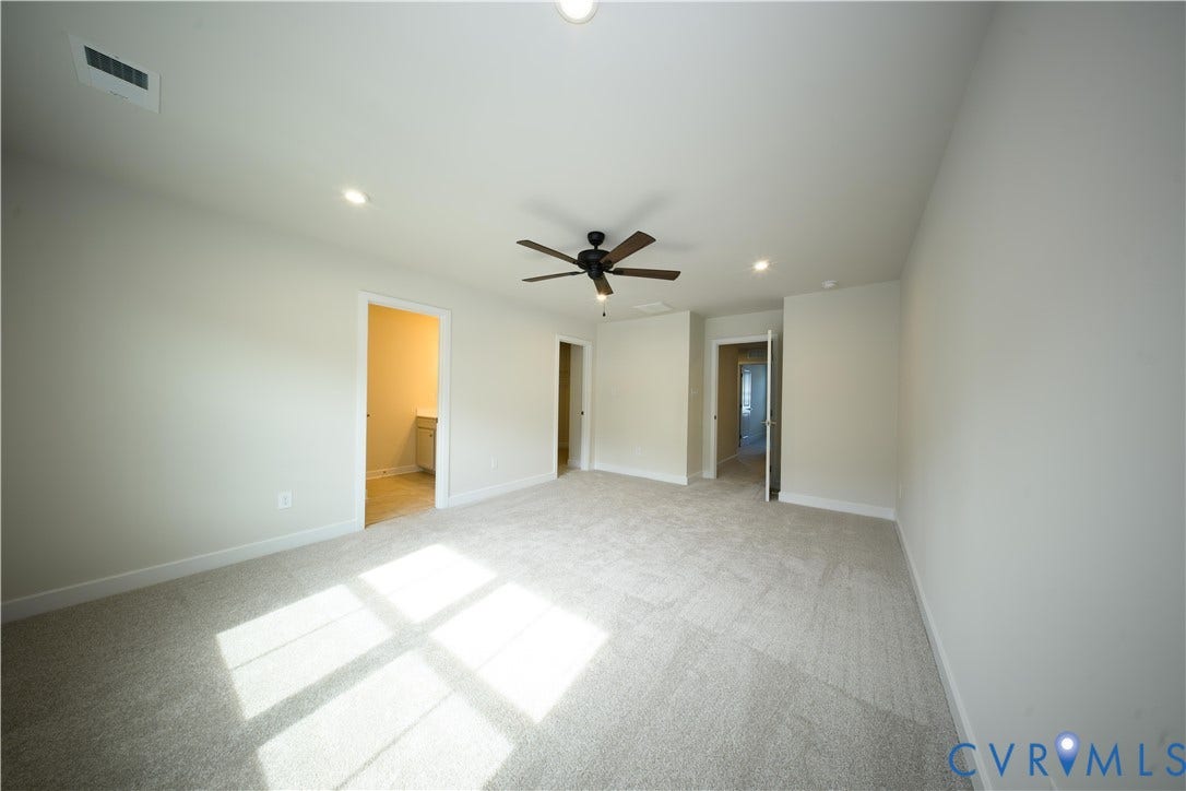 Expansive carpeted room featuring a ceiling fan, recessed lighting, and light-toned walls