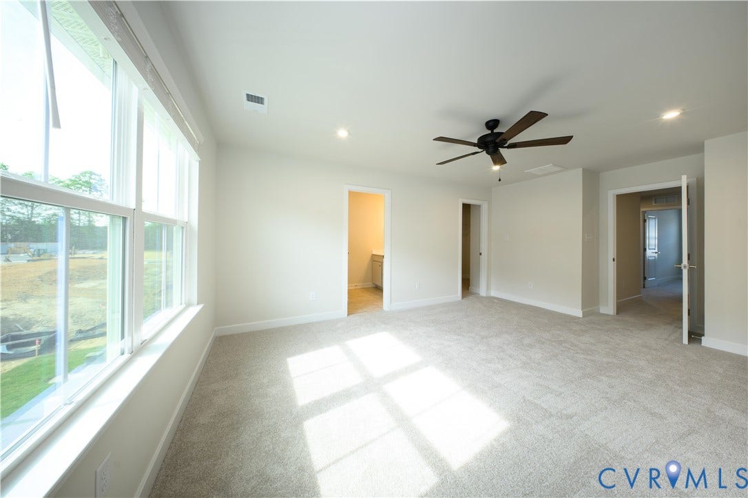 Expansive room featuring carpet flooring, large windows, a ceiling fan, and recessed lighting