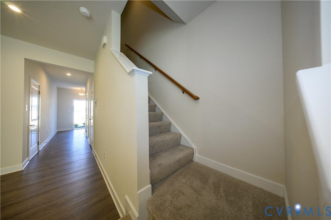 Carpeted staircase with wooden handrail