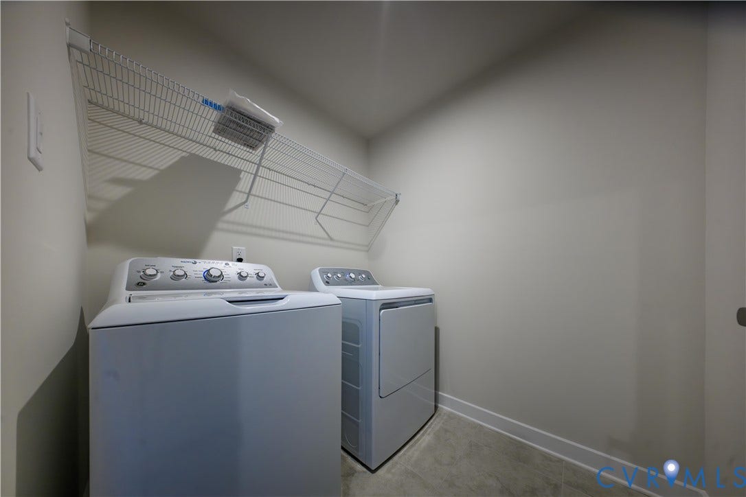 Dedicated laundry area featuring a wire storage shelf and light-toned walls