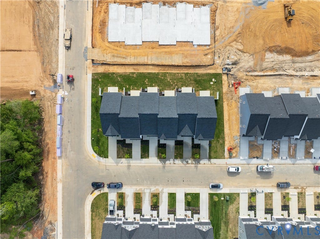 Newly constructed residential community featuring multi-unit properties with dark shingle roofs