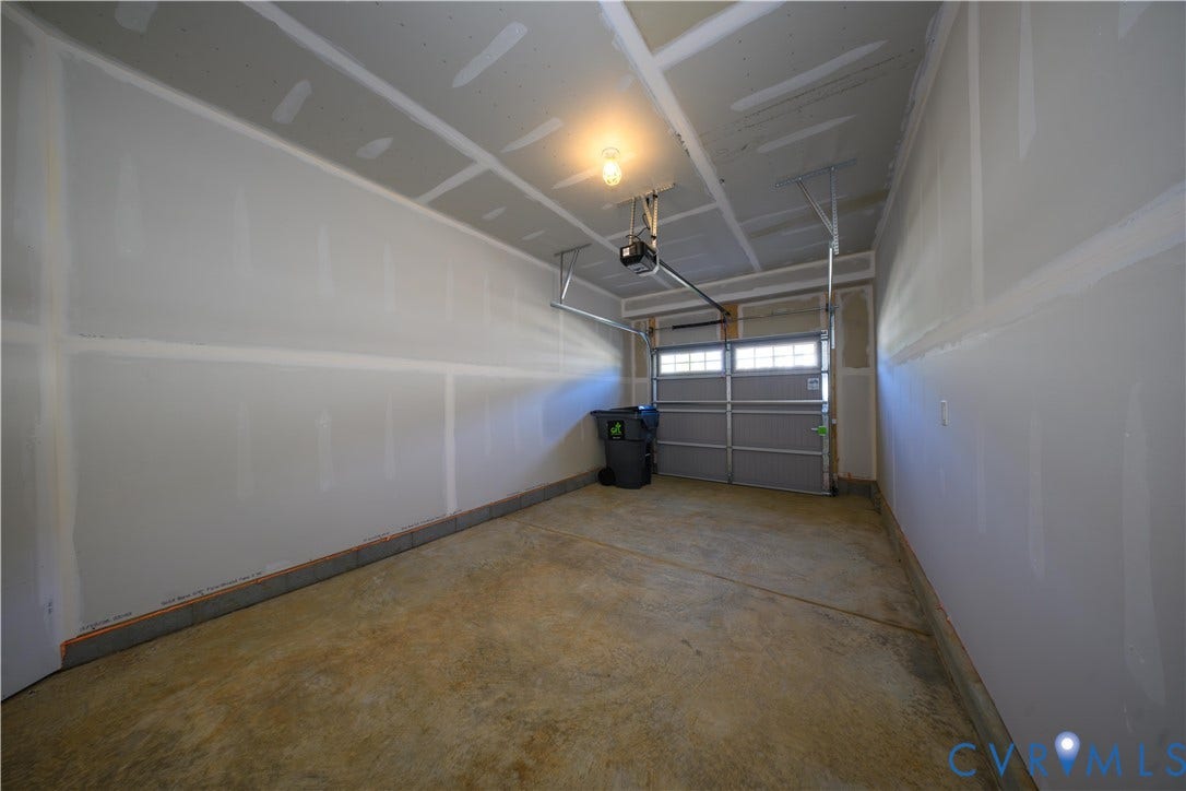 Single-car garage with a paneled door, integrated windows, and an automatic garage door opener
