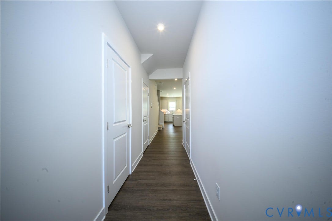 Hallway featuring wood-finish flooring, recessed lighting, and white paneled doors