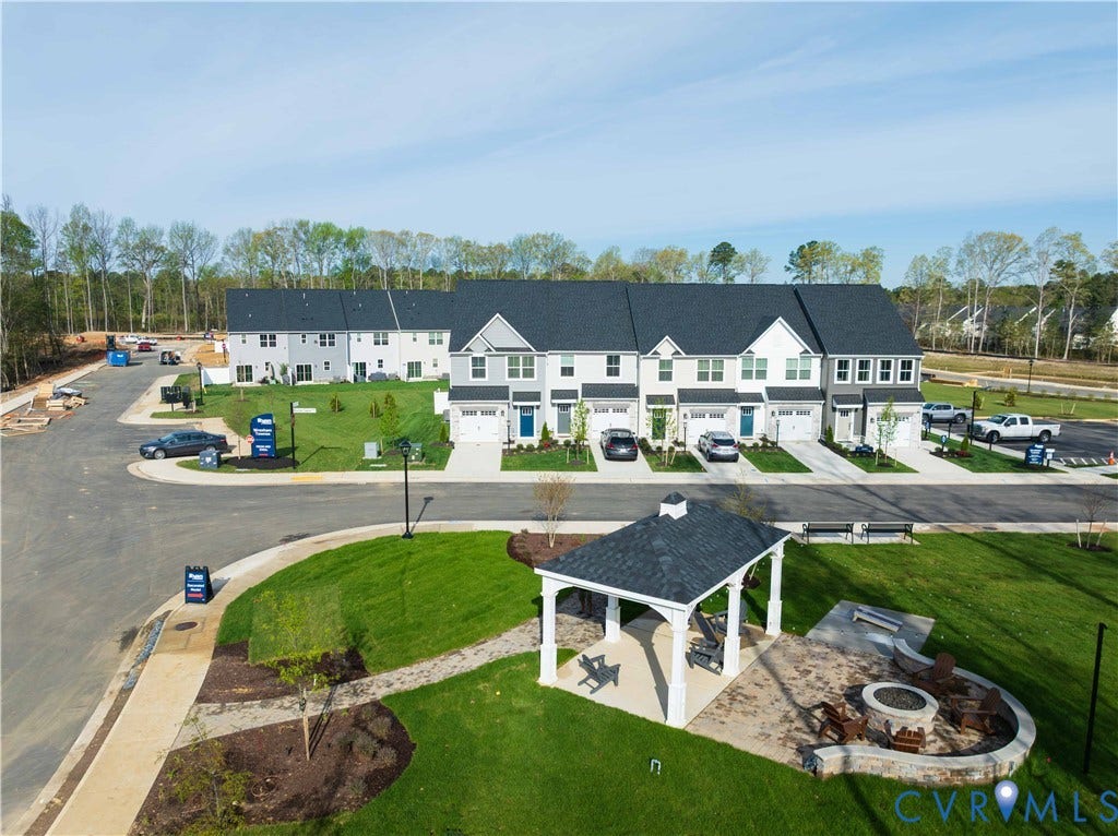 Community green space featuring a gazebo, built-in seating, and a fire pit